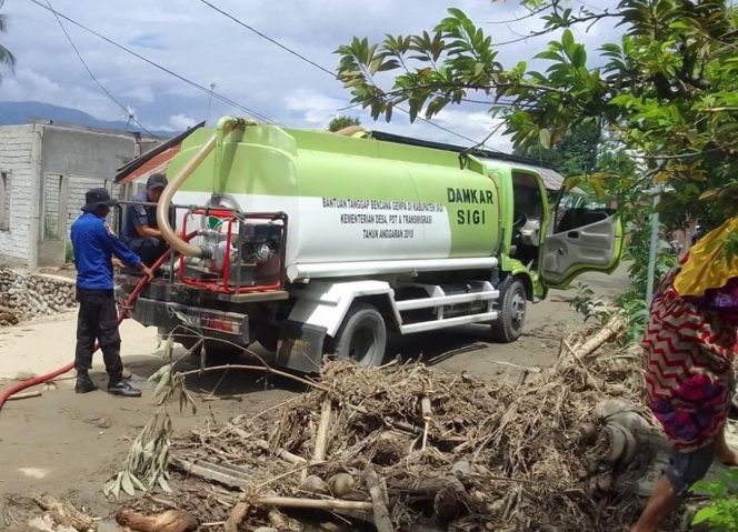 
					Suasana saat Damkar dan Pol PP Sigi salurkan air bersih kepada warga kobran banjir. photo: ist