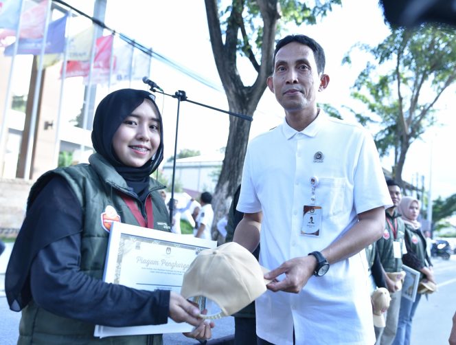 
					Ketua KPU Kota Palu, Idrus secara simbolis melepas seragam Pantarlih usai Apel Akbar pada Kamis (25/07/24). photo: netiz.id (akib)
