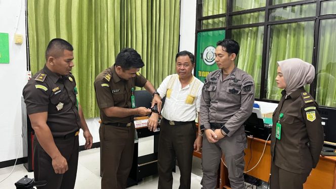 
					Tersangka kasus korupsi pengadaan Alat Tepat Guna (TTG), DB Lubis saat dipasangi Gelang Detektor oleh Kejaksaan Negeri Donggala. photo: netiz.id (akib)