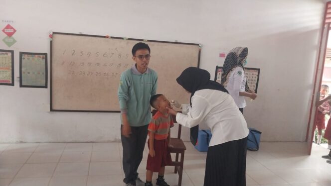 
					Kepala Puskesmas Delatope, Ronawati, saat memberikan vaksin polio dosis dua. FOTO: TIM