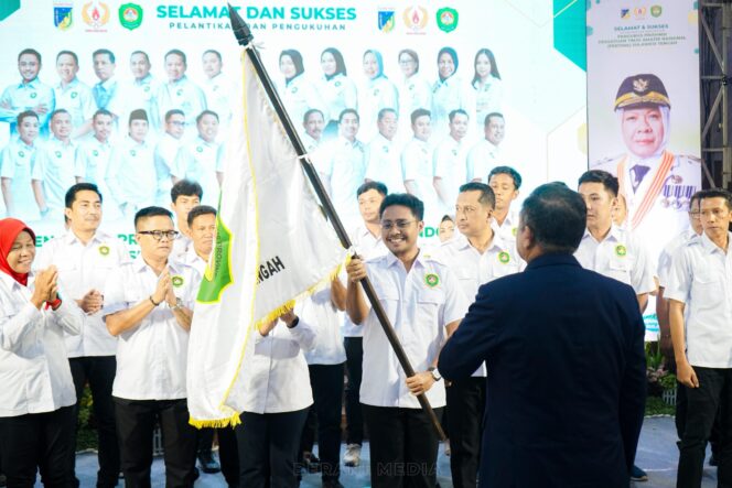 
					Ketua Umum PB Pertina Mayjen TNI (Purn) Dr. (Cand.) Komaruddin Simanjuntak menyerahkan bendera pataka kepada Ketua Pertina Sulawesi Tengah terpilih, Fathur Razaq Anwar, sebagai simbol kepemimpinan baru masa bakti 2025–2029, dalam acara pelantikan dan pengukuhan pengurus di Tanaris Ballroom, Kota Palu, Rabu (28/05/25). FOTO: istimewa