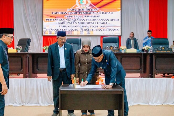 
					Wakil Bupati Morowali Utara, H. Djira K., S.Pd., M.Pd., menandatangani dokumen persetujuan bersama dalam Rapat Paripurna DPRD Morowali Utara terkait pertanggungjawaban pelaksanaan APBD Tahun Anggaran 2024, didampingi pimpinan dan anggota DPRD, Selasa (01/07/25). FOTO: istimewa