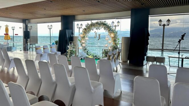 
					Suasana dekorasi pernikahan bertema Intimate Wedding di venue Seaside Indoor Swiss-Belhotel Silae Palu, dengan latar pemandangan Teluk Palu yang memukau. FOTO: istimewa