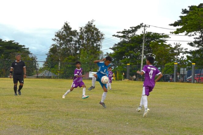 
					Pemain Darma Putra (biru) mengontrol bola dihadang pemain Buol United (ungu) pada laga perdelapan final Piala Soeratin U13 Sulteng 2025–2026 di Lapangan PS Kilat Silae, Palu, Selasa (19/08/25). FOTO: netiz.id
