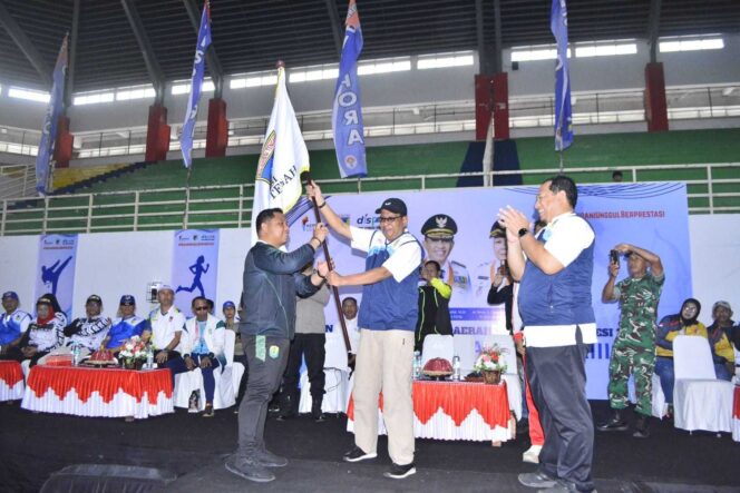 
					Kadisporapar Kabupaten Buol, Purnomo, menerima bendera POPDA Sulawesi Tengah dari perwakilan panitia pada penutupan POPDA XXIII 2025 di GOR Andi Raga Pettalolo Palu, Jumat (29/08/25). FOTO: CLG 
