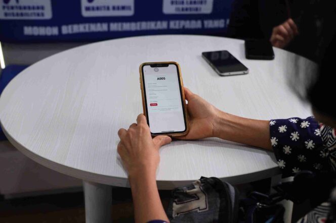 
					Seorang pemohon menunjukkan tampilan fitur Antrian Online pada aplikasi Sentuh Tanahku di ponsel saat berada di Kantor Pertanahan Kabupaten Karawang, Selasa (29/10/25). FOTO: istimewa