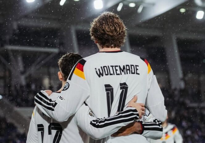 
					Dua pemain Timnas Jerman saling berpelukan merayakan gol di bawah rintik hujan, dengan Nick Woltemade yang menjadi bintang lapangan setelah mencetak dua gol dalam kemenangan atas Luxembourg. FOTO: (IG) @dfb_team