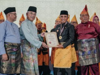 Gubernur Sulawesi Tengah Anwar Hafid (tengah) menerima piagam pelantikan sebagai Ketua Dunia Melayu Dunia Islam (DMDI) Provinsi Sulawesi Tengah dalam prosesi pelantikan yang berlangsung di Ballroom Best Western Hotel, Palu, Senin (26/01/26). FOTO: istimewa