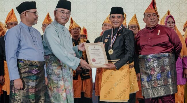 Gubernur Sulawesi Tengah Anwar Hafid (tengah) menerima piagam pelantikan sebagai Ketua Dunia Melayu Dunia Islam (DMDI) Provinsi Sulawesi Tengah dalam prosesi pelantikan yang berlangsung di Ballroom Best Western Hotel, Palu, Senin (26/01/26). FOTO: istimewa
